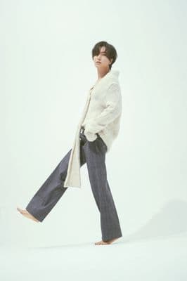 a woman in a white sweater and blue pants