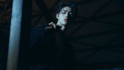 a young man holding a baseball bat in the dark