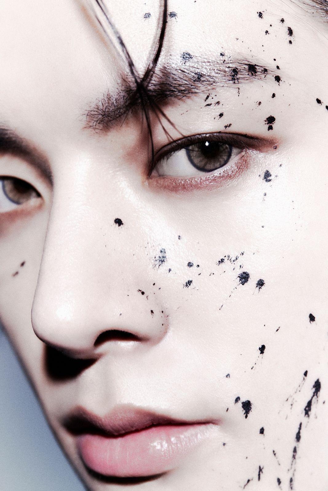a close up of a person with black spots on his face