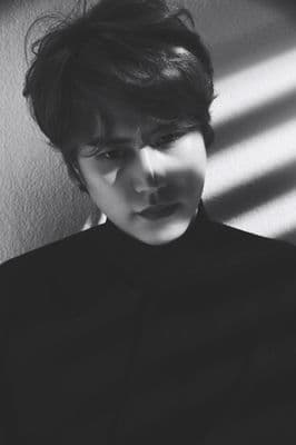 a person with a black shirt and a shadow on a wall