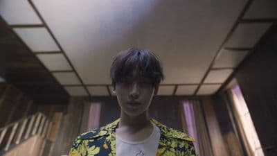 a young man in a yellow and blue jacket