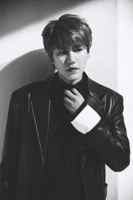 a young man in a leather jacket poses for a picture