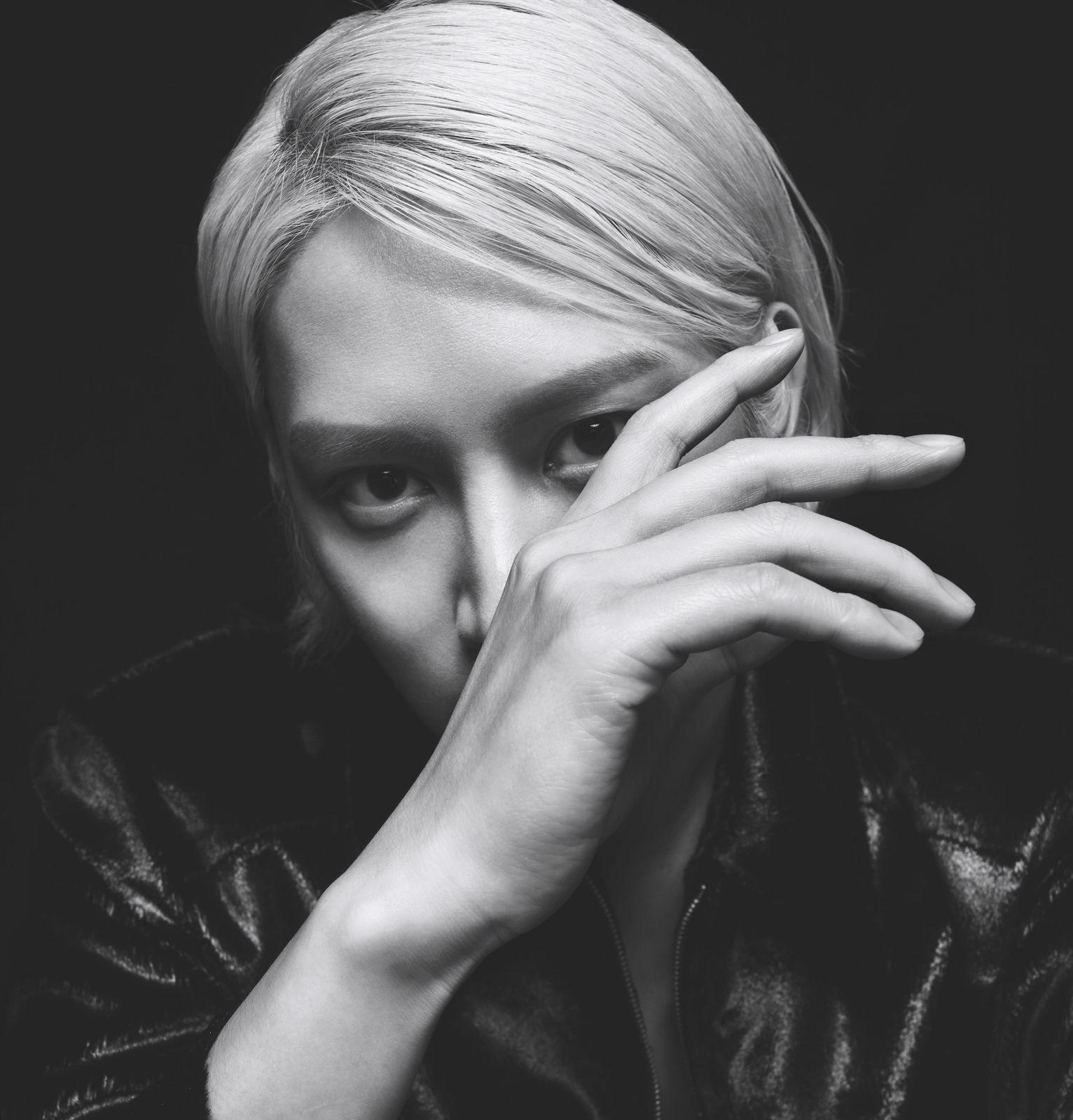 a black and white photo of a woman covering her face