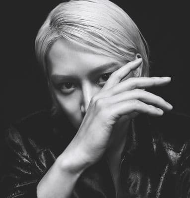a black and white photo of a woman covering her face