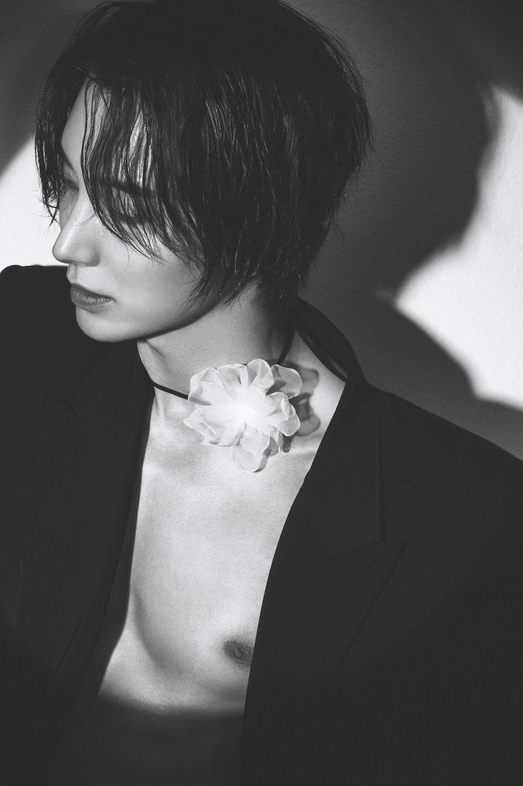 a black and white photo of a woman with a flower in her hair