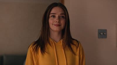 a woman in a yellow shirt standing in a room