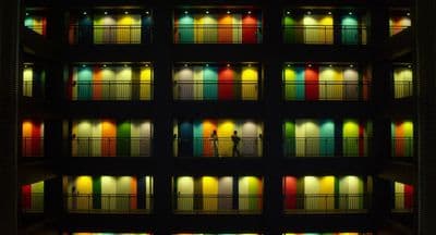 a multicolored building with a person standing in front of it