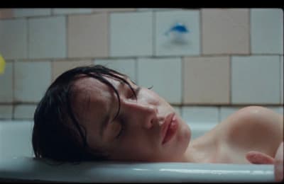a young man laying down in a bathtub