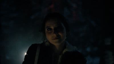 a woman standing in the dark in the dark