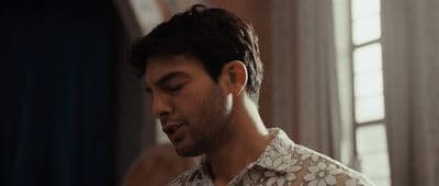 a man standing in front of a window with his eyes closed