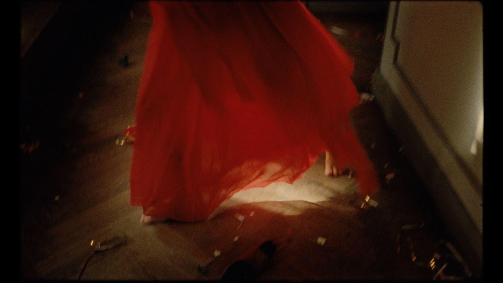 a woman in a red dress standing in a room
