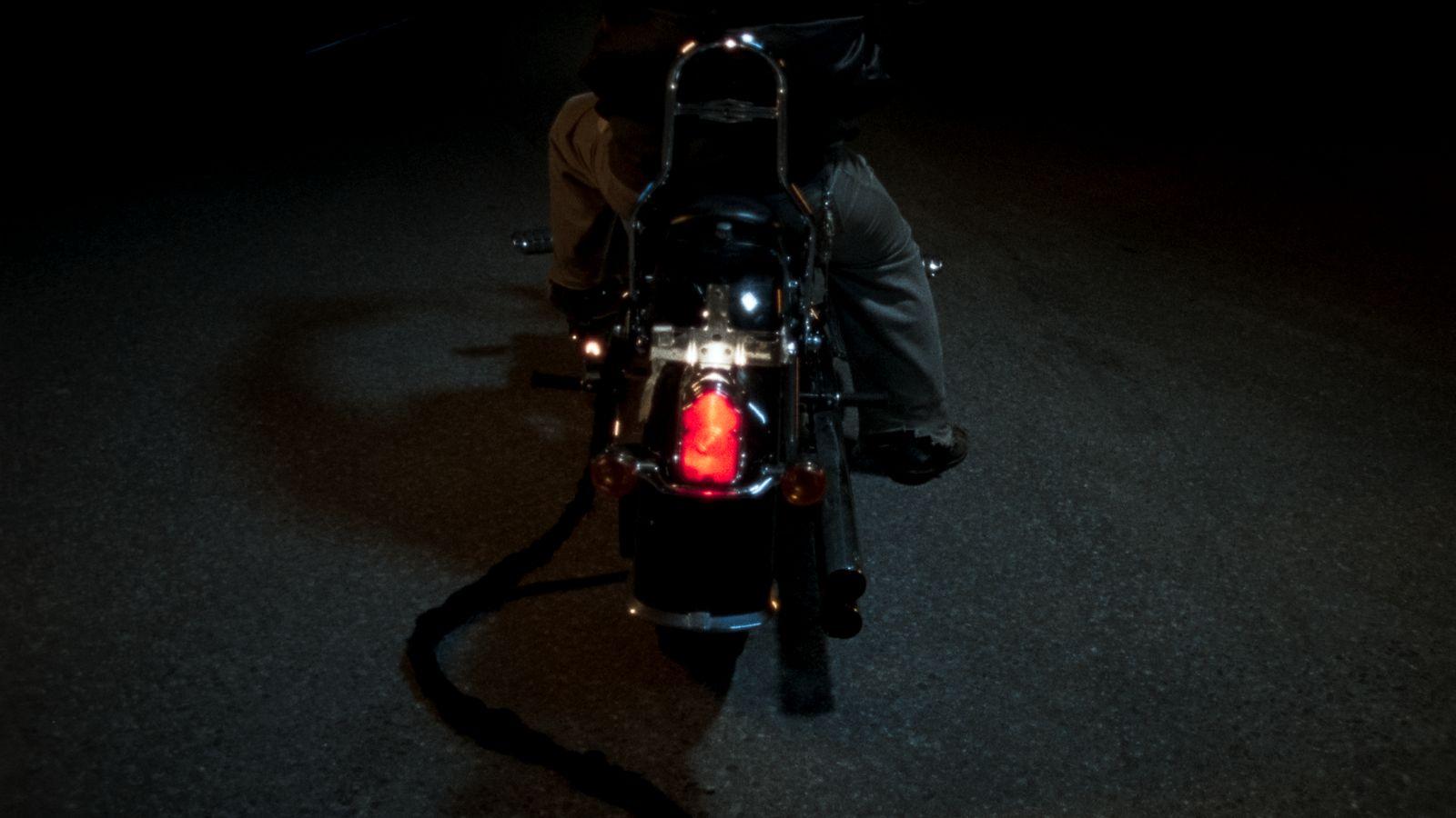 a person riding a motorcycle in the dark