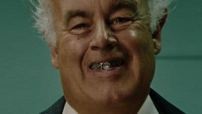 a close up of a person wearing a suit and tie