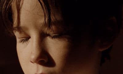 a close up of a child's face with eyes closed