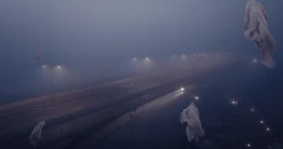 a foggy night with several people walking in the fog