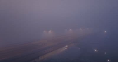a foggy street with street lights on a foggy day