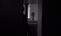 a black and white photo of a person standing in a room