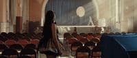 a woman standing in front of a room filled with chairs