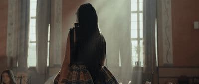 a woman with long hair standing in a room