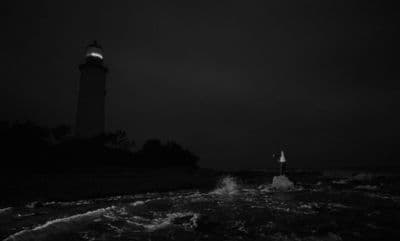 a black and white photo of a lighthouse at night