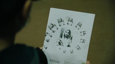 a person holding up a paper with a picture of jesus on it