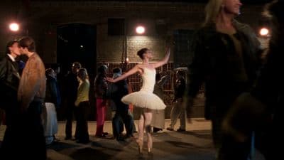 a woman in a white tutu dancing in front of a crowd of people