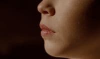 a close up of a woman's face in the dark
