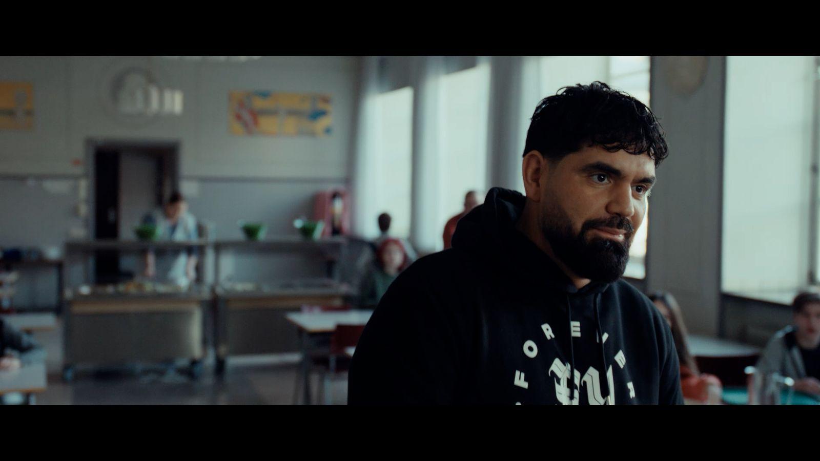 a man in a black hoodie standing in a room
