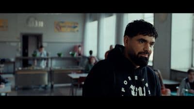 a man in a black hoodie standing in a room