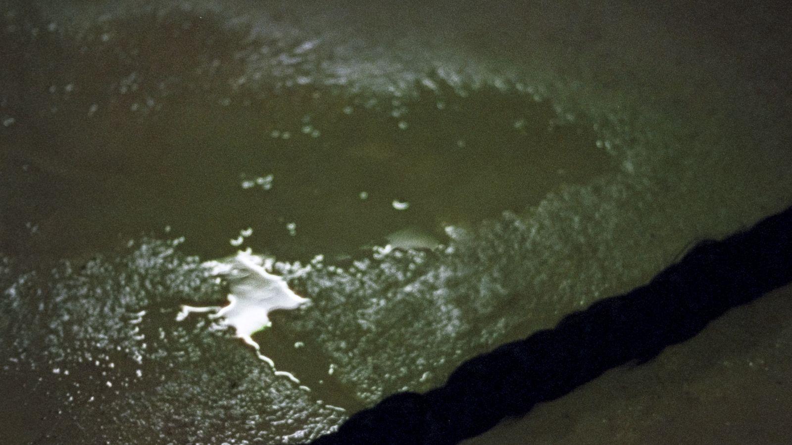 a person standing in the water with a surfboard