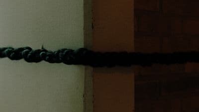 a close up of a black rope on a wall