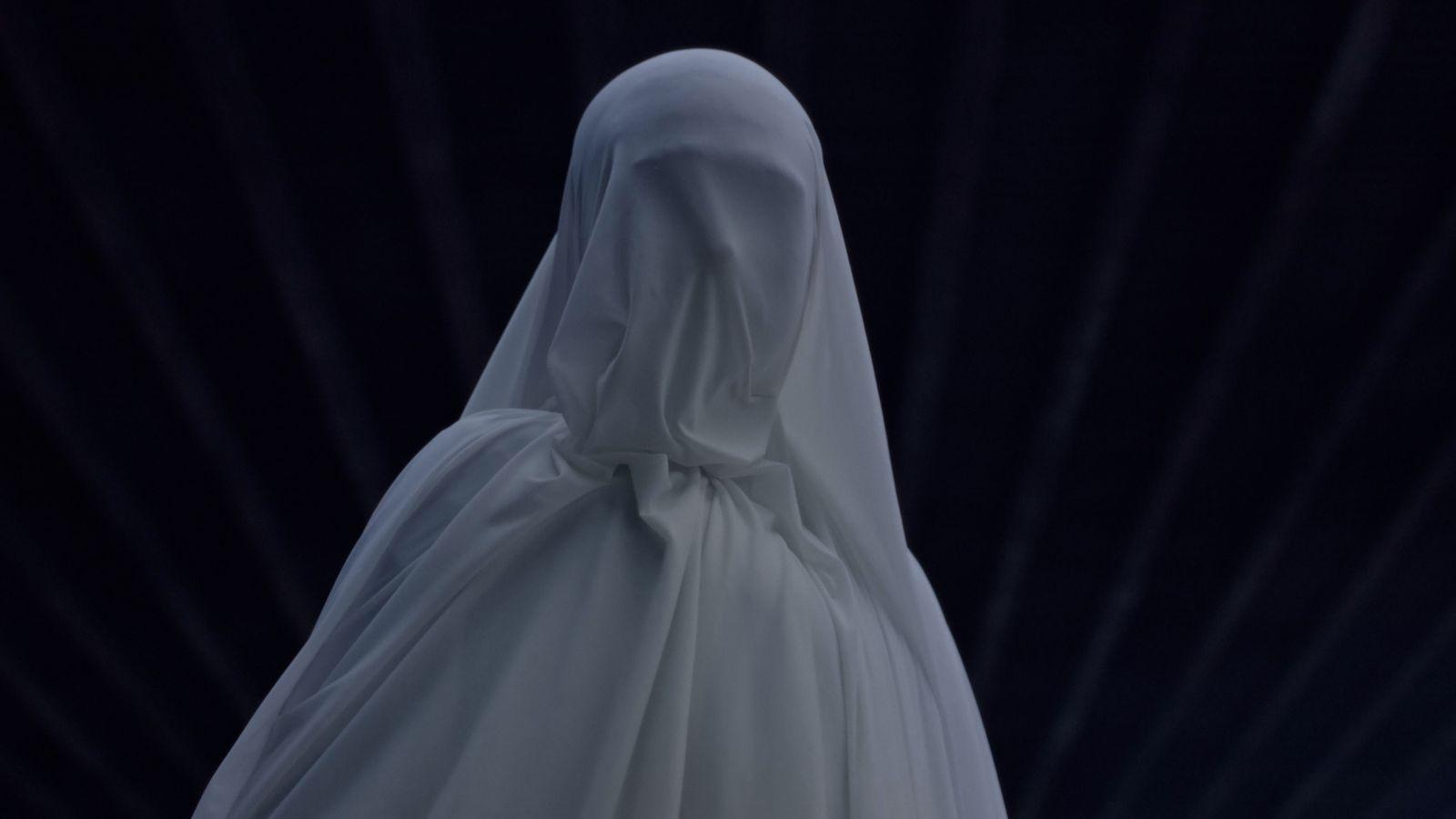a woman in a white dress with a veil on her head