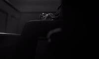 a person sitting in a chair in a dark room
