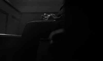a person sitting in a chair in a dark room