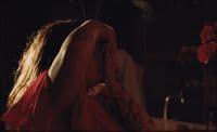 a woman in a red dress sitting in front of a sink