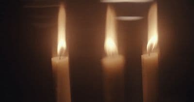 a group of lit candles sitting next to each other