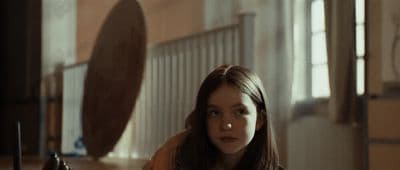 a young woman sitting on the floor in front of a mirror