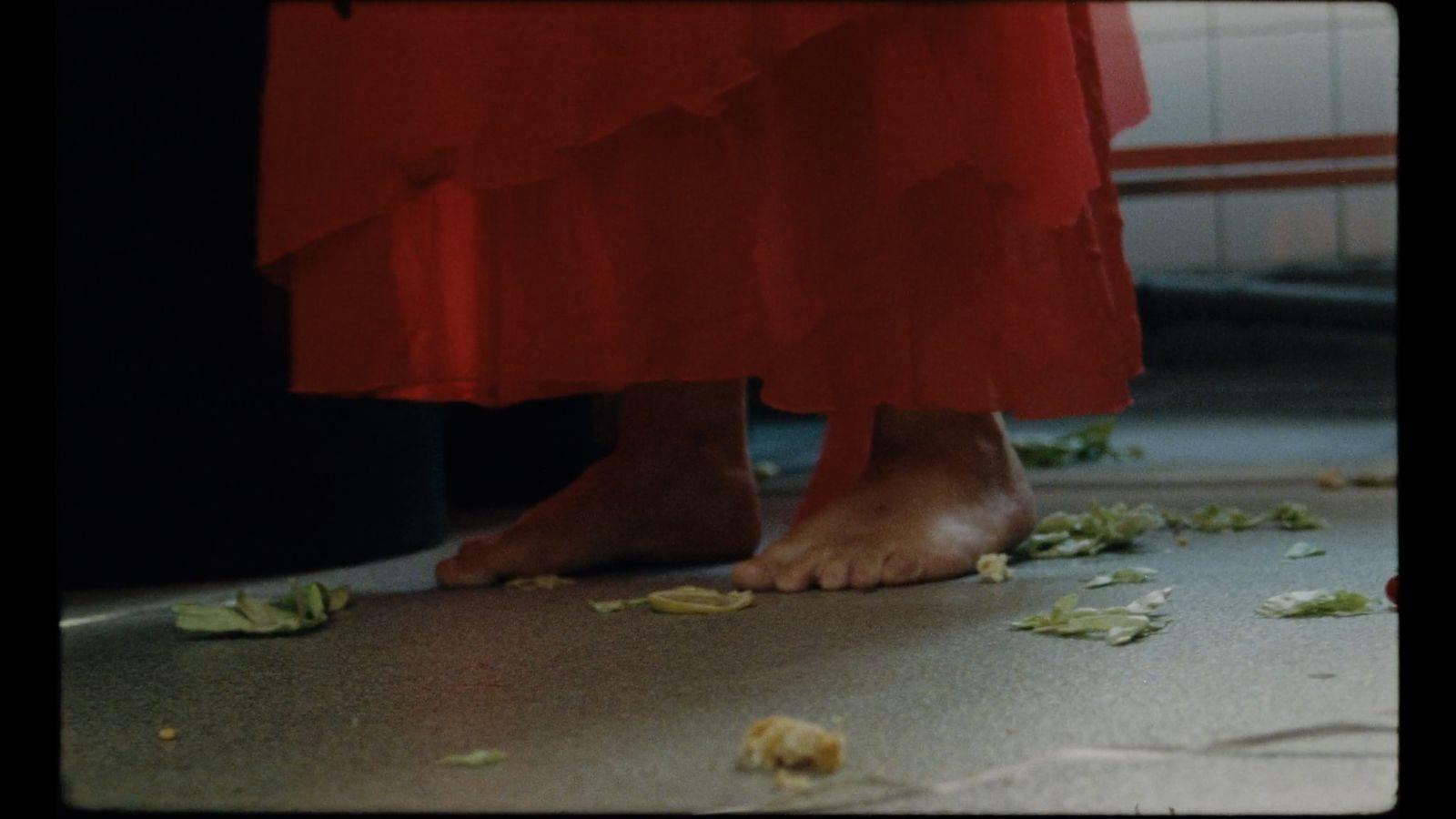 a close up of a person's feet with petals on the ground