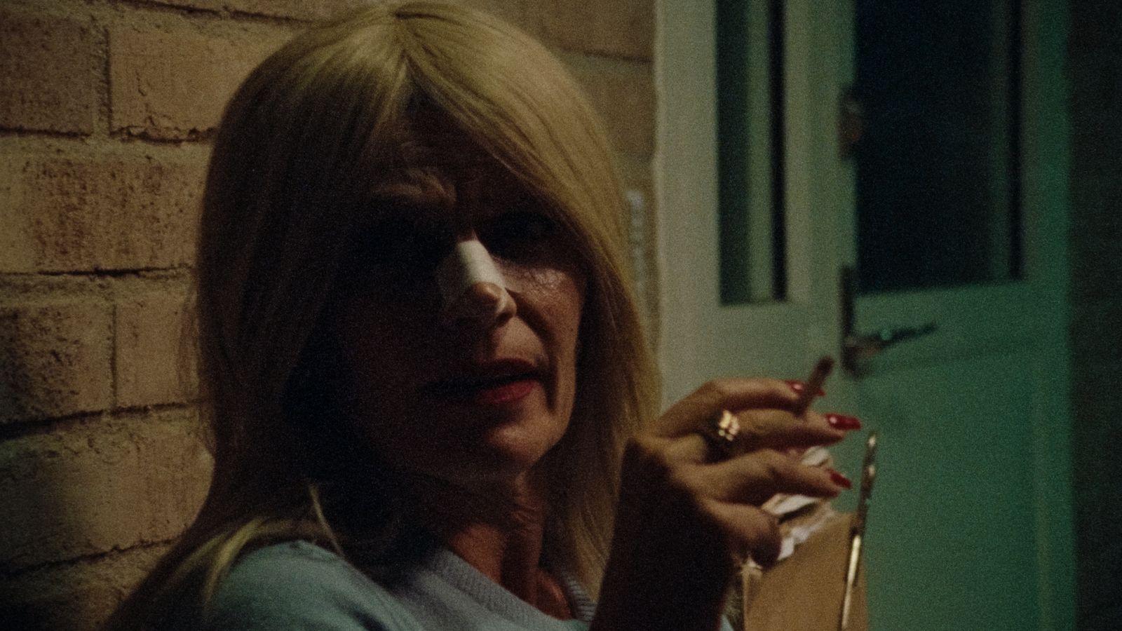 a woman holding a cigarette in her right hand