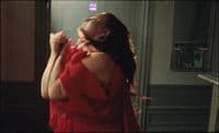 a woman in a red dress standing in a room