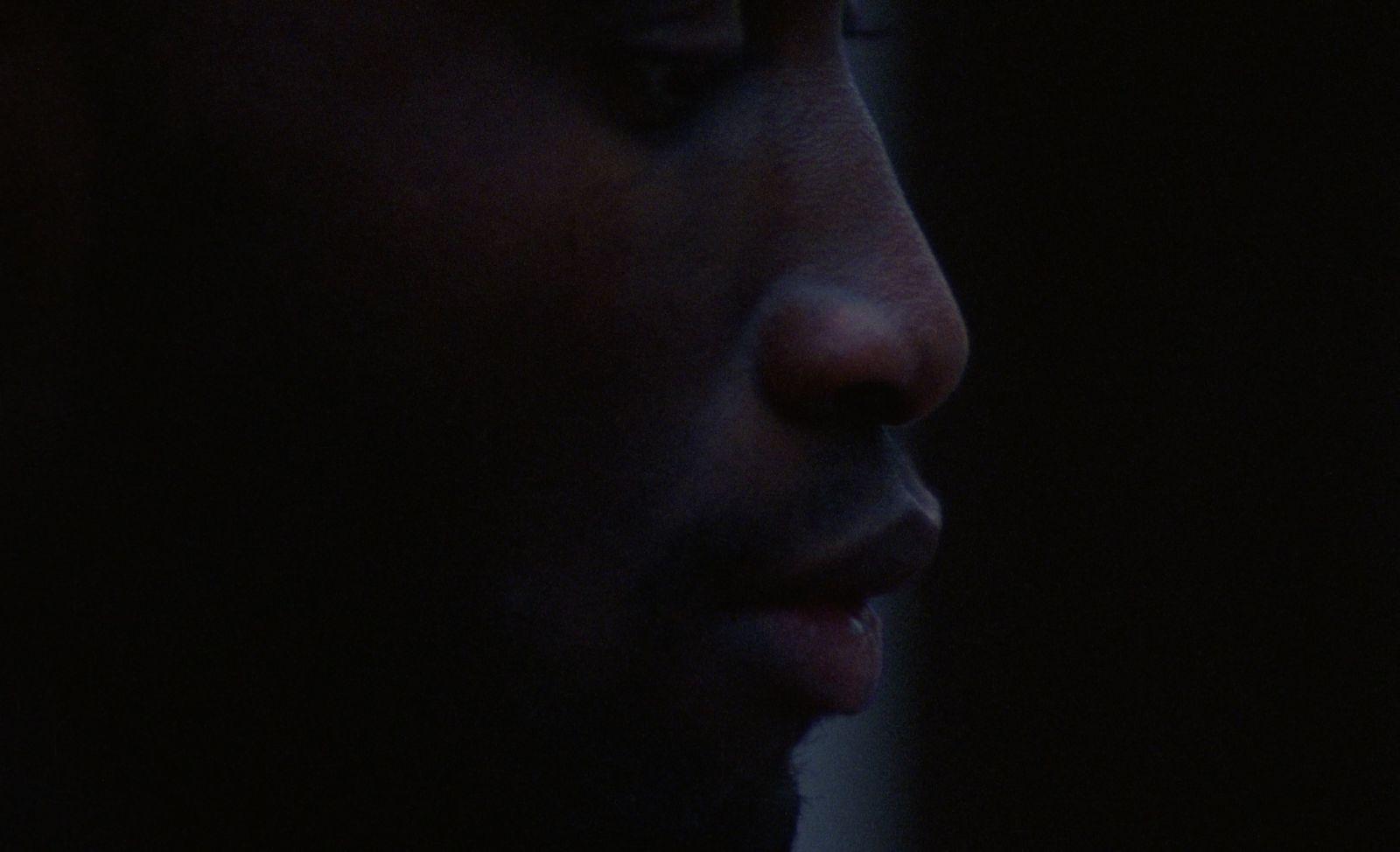 a close up of a man's face in the dark