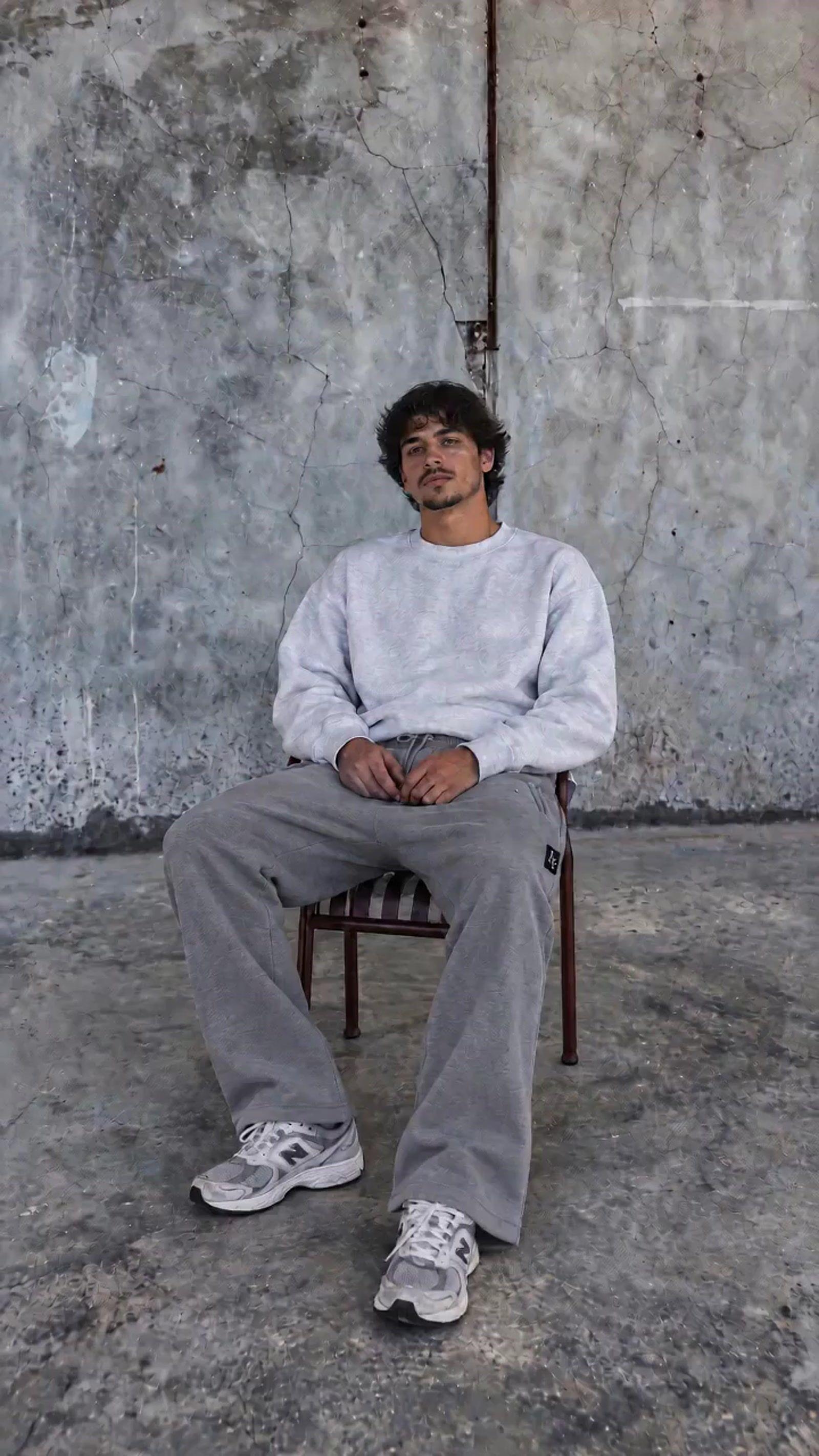 a man sitting in a chair in front of a wall