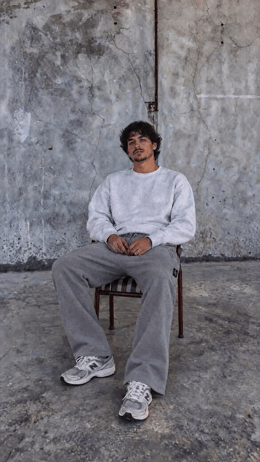 a man sitting in a chair in front of a wall