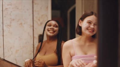a couple of women standing in front of a mirror