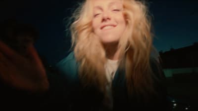 a woman with long blonde hair smiling at the camera