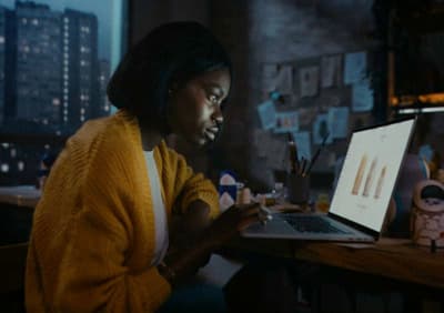a woman sitting in front of a laptop computer