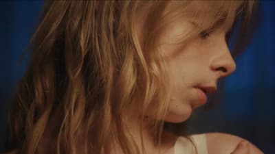 a young girl with long blonde hair is staring at the camera