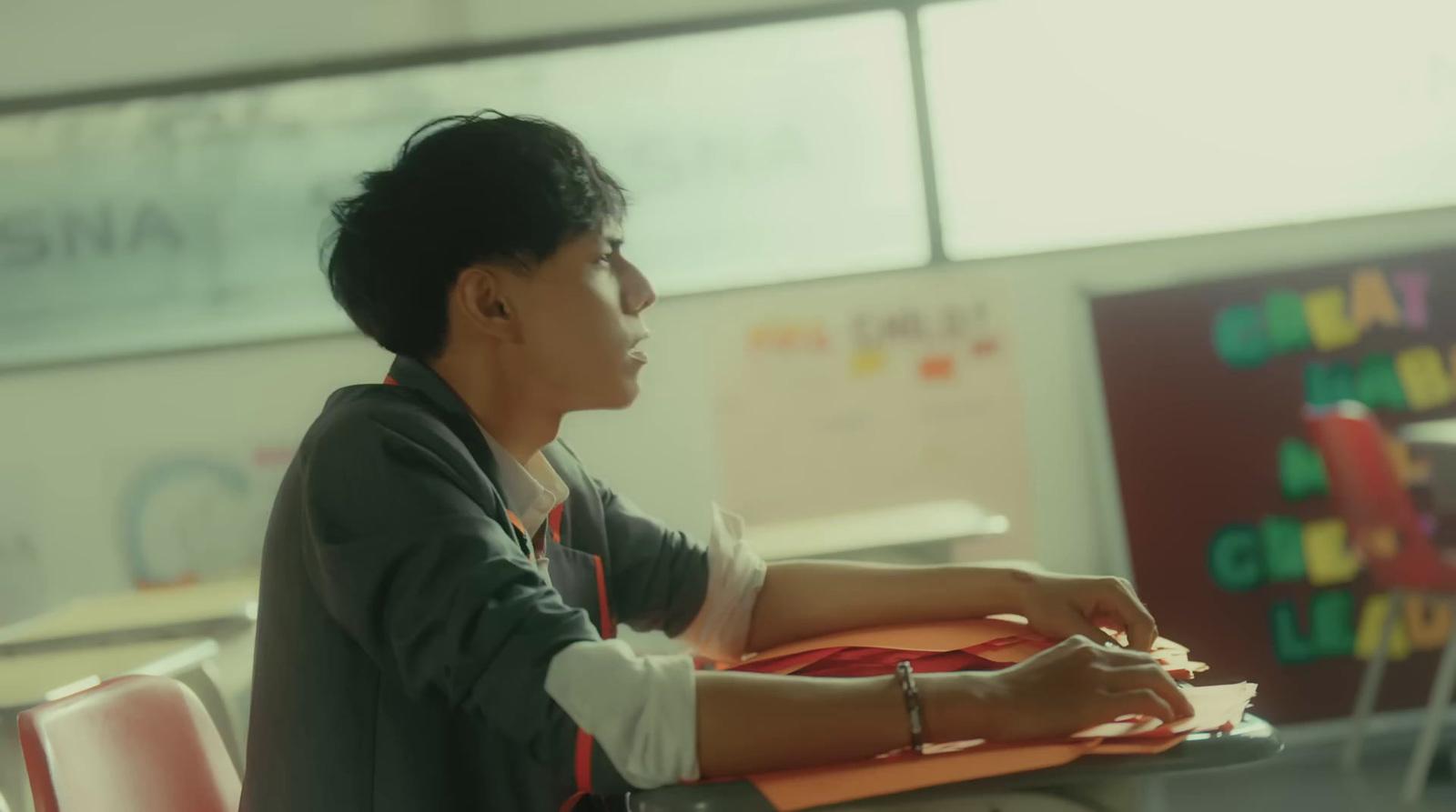 a woman sitting at a desk in a classroom