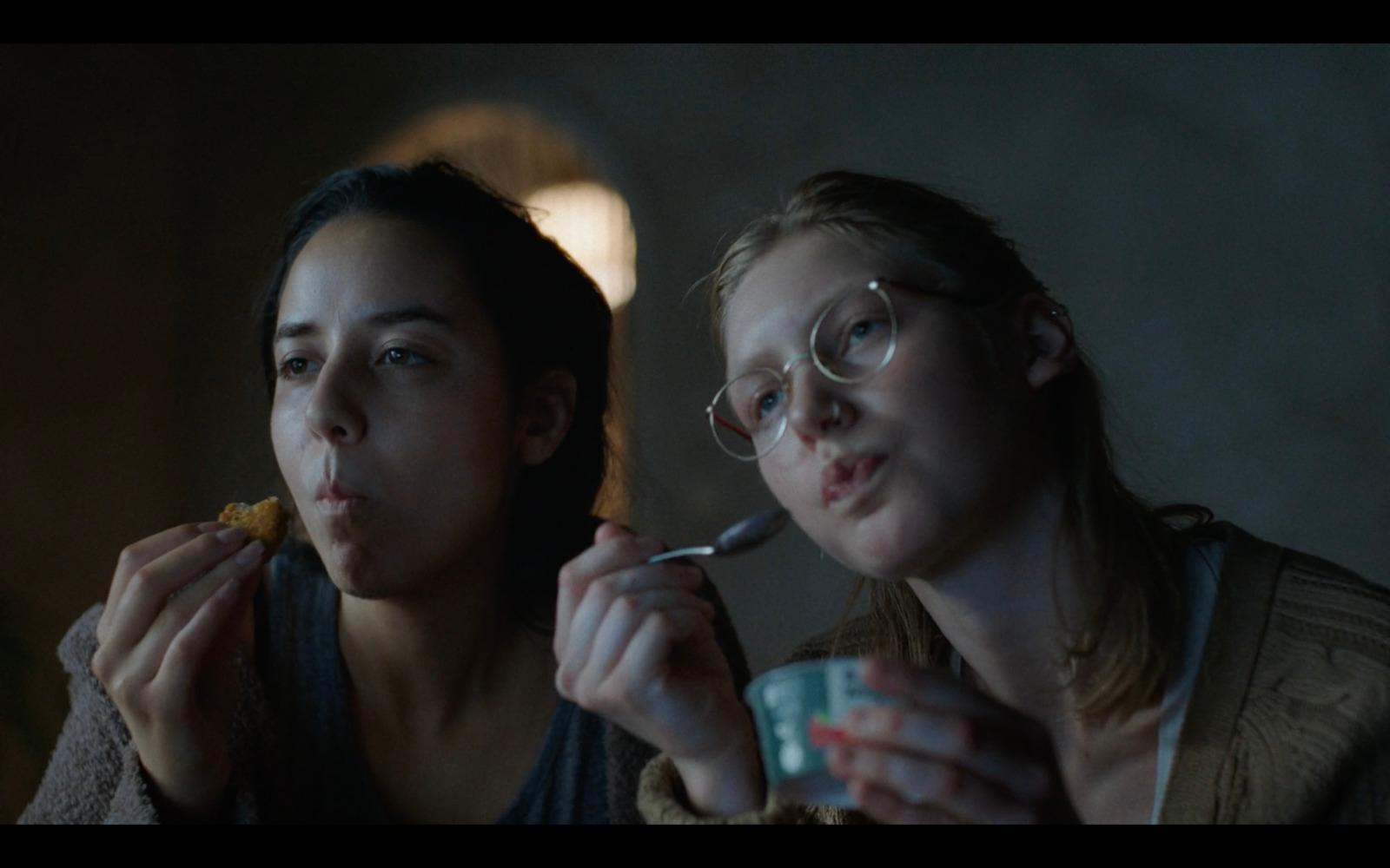 two women are eating food and drinking coffee
