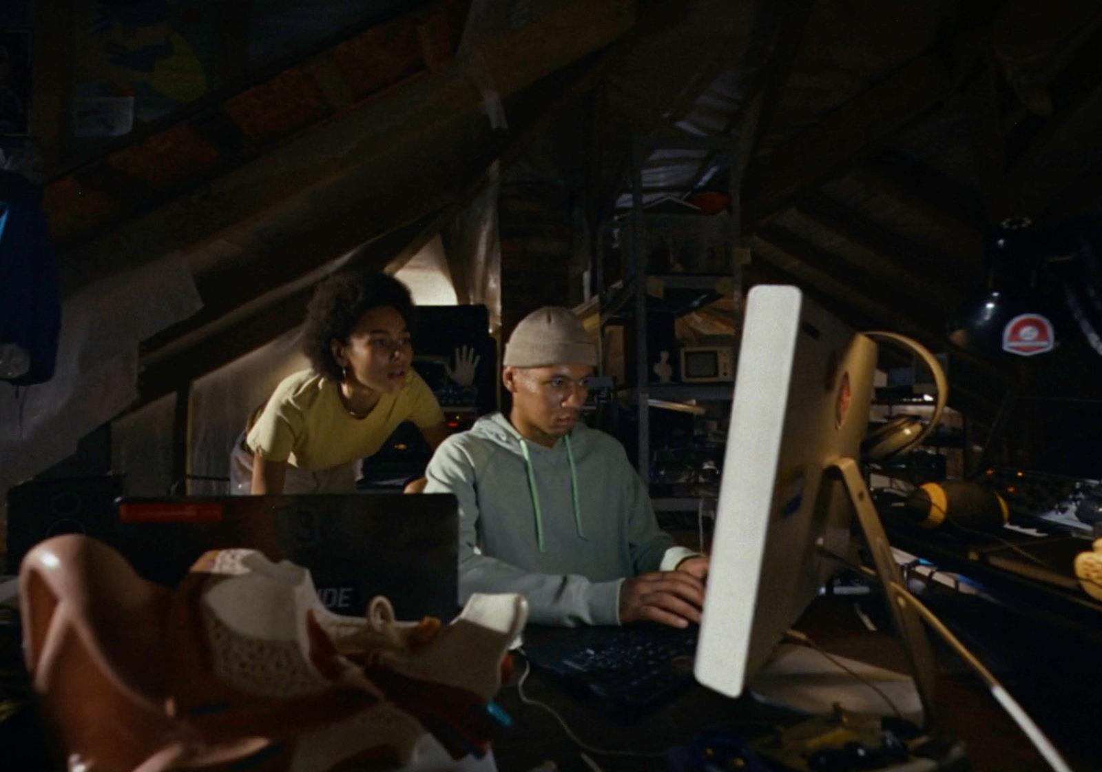 a couple of people sitting at a computer desk